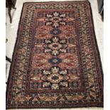 A Caucasian rug, the central panel set with three repeating medallions on a red and blue ground,