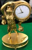 A 19th Century French gilt brass figural mantel clock as a robed maiden holding aloft a drum,