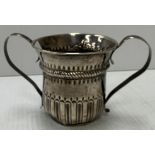 A George III silver loving mug with embossed decoration and initialled "WL" (by John Moore,