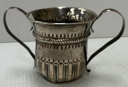 A George III silver loving mug with embossed decoration and initialled "WL" (by John Moore,