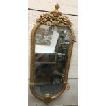 A giltwood and gesso framed girandole pier glass with flaming urn and musical instrument cornice