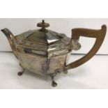 A George V silver teapot of elongated octagonal form with wooden handle and finial,