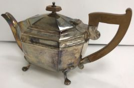 A George V silver teapot of elongated octagonal form with wooden handle and finial,