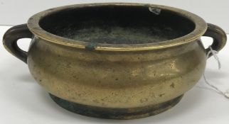 A Chinese bronze censer of plain baluster form with simple tapering loop handles on a circular foot,