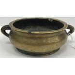A Chinese bronze censer of plain baluster form with simple tapering loop handles on a circular foot,