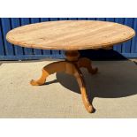 A waxed pine circular kitchen table on centre pedestal to tripod base, 136 cm diameter x 73 cm high,