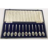 A cased set of twelve Elizabeth II silver and enamel decorated coffee spoons,