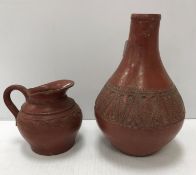 A Redware gourd shaped pottery vase with central band of foliage on a plain ground raised on a