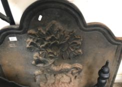 A wrought iron cast iron fire back decorated with horse and tree, 75 cm wide x 66 cm high,