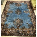 A Persian carpet, the central panel set with scrolling floral sprays on a blue ground,