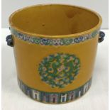 A 19th Century Chinese famille jaune cylindrical pot with twin mask side handle holders,