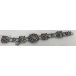 A Zoltan White & Co. sterling silver gem set bracelet with flower head decoration, 18.