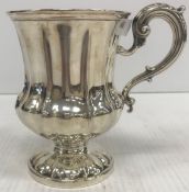 A Victorian silver tankard of waisted gourd stylised form with scrolling handle,