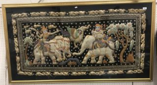 A 20th Century Indonesian embroidered and sequinned panel depicting "Two figures and elephants with