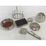 A collection of silver wares comprising silver four section toast rack of simple form,