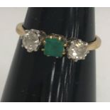An 18-carat gold diamond and emerald three stone ring, size O, 2.