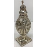 A George III silver pepper of reeded egg form, raised on square base (George Newburn, London 1811),