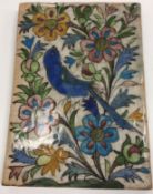 A 19th Century Qajar pottery tile with painted bird and floral decoration,