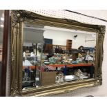 A modern gilt swept framed wall mirror with rectangular bevel edge plate 91 cm x 64.