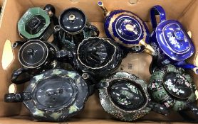 Seven circa 1900 black glazed and gilt decorated teapots, various makers and designs,