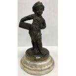 A Dutch bronze statue of a barefoot child in cap carrying basket sat on a stepped marble pedestal