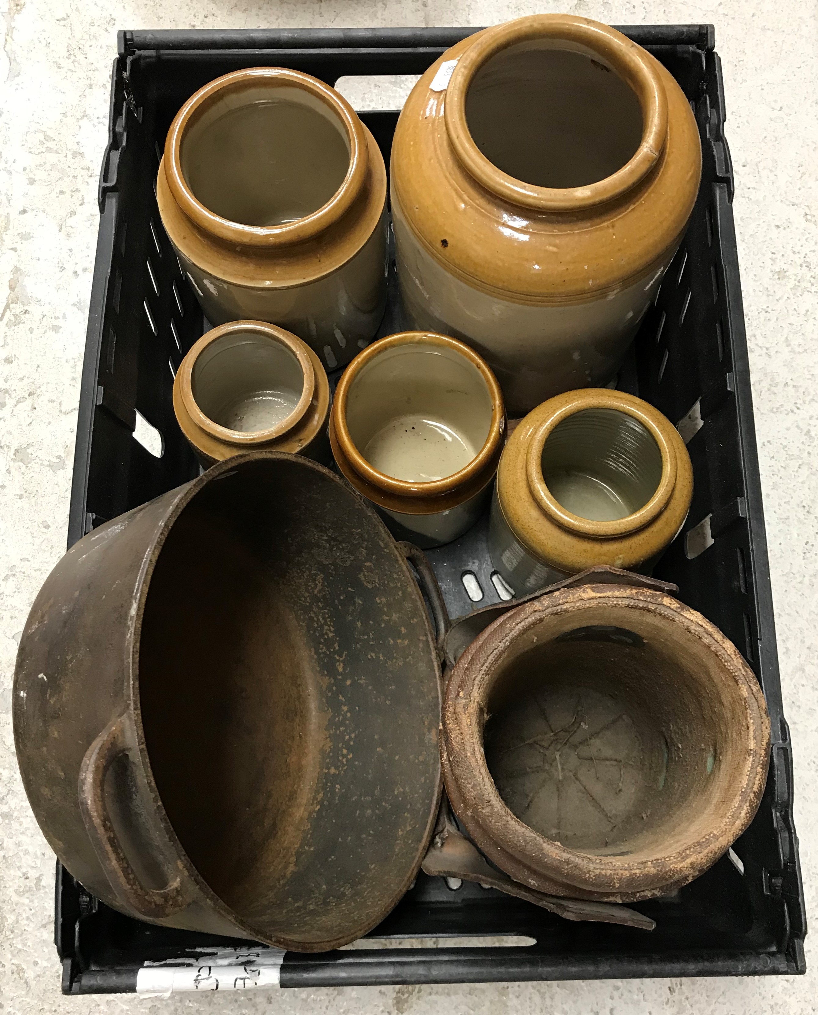 A collection of items to include a crate containing various stoneware jars, a cast iron pan,