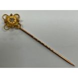 A yellow metal diamond set tie pin, 6 cm long,