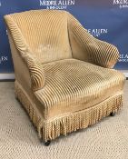 A late Victorian gold striped upholstered salon arm chair on turned ebonised front legs to brass