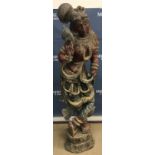 An Indian carved and painted wooden figure of an Apsara on a carved lotus leaf pedestal base 160 cm