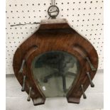 An early 20th Century oak horseshoe shaped hall mirror with brass square cut nail hooks 38 cm wide