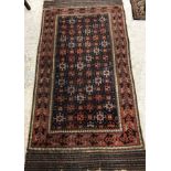 A Persian rug, the central panel set with repeating tiled decoration on a dark blue ground,