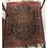 A Turkish style prayer rug, the central panel set with flower head motifs on a dark blue ground,