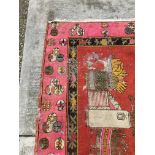 An Oriental rug, the central panel set with flower filled vases on a bright red ground,