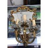 A pair of brass girandole three branch wall sconces with fake mirrored plate and scrolling