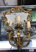 A pair of brass girandole three branch wall sconces with fake mirrored plate and scrolling