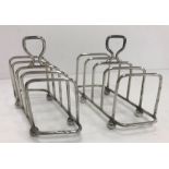 A pair of George V silver four section toast racks of offset rectangular or parallelogram form,