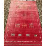 A Moroccan Kelim rug, the central panel decorated with various geometric motifs on a red ground,