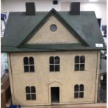 A circa 1890 late Victorian doll's house with painted green roof and pebble dash style exterior,