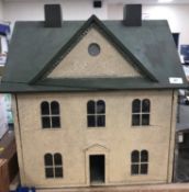 A circa 1890 late Victorian doll's house with painted green roof and pebble dash style exterior,