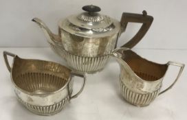 A Victorian silver three-piece tea set of oval form with semi-reeded decoration (Birmingham 1886),