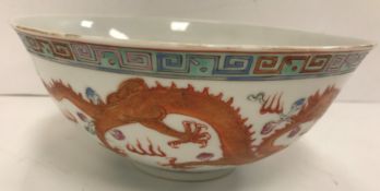 A Chinese porcelain bowl decorated in oxide red and gilt highlighting with five toed dragons