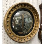 An early 19th Century giltwood and gesso framed circular wall mirror with ball decoration and
