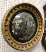 An early 19th Century giltwood and gesso framed circular wall mirror with ball decoration and