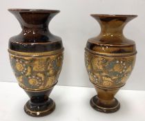 A near matching pair of Royal Doulton lacework decorated vases 15 cm and 14.