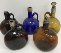 A collection of five 19th Century coloured glass flagons (three brown, one amber,
