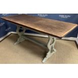 A modern oak refectory style dining table on painted base with end trestle supports united by a