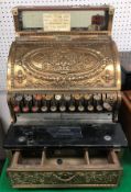 A late Victorian brass cased National cash register (LSD) with all over scrolling foliate and