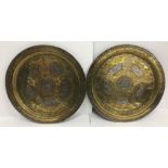 A pair of Middle Eastern brass white metal and copper inlaid chargers with script and foliate