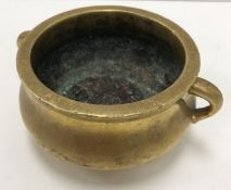 A Chinese polished brass censer of bellied form with openwork handles,
