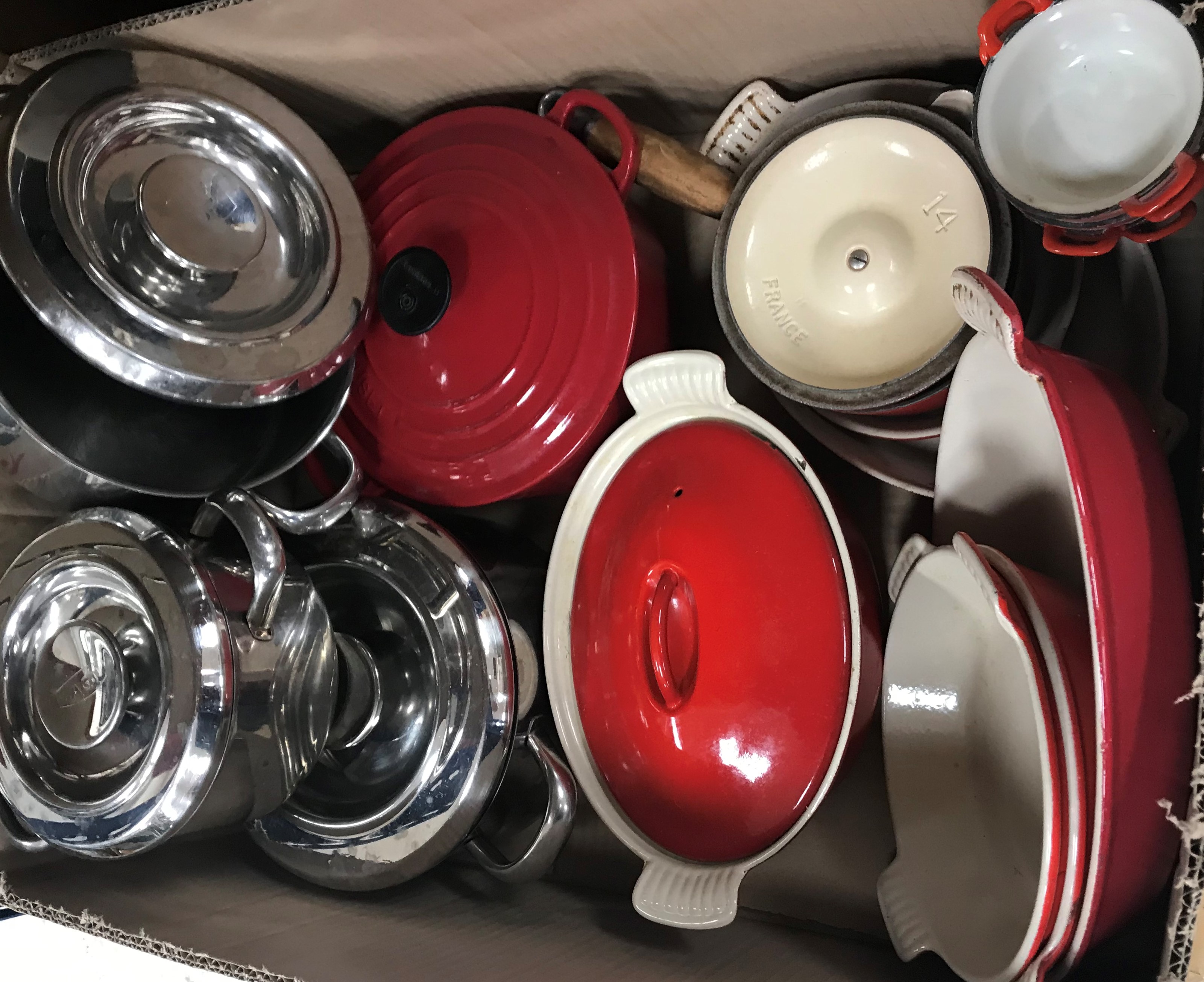 A box containing three Aga saucepans, Le Cruset saucepan,